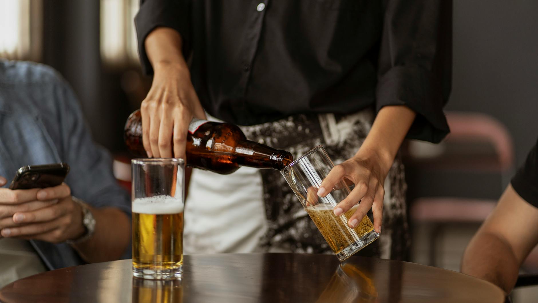 waitress filling up the glass with beer