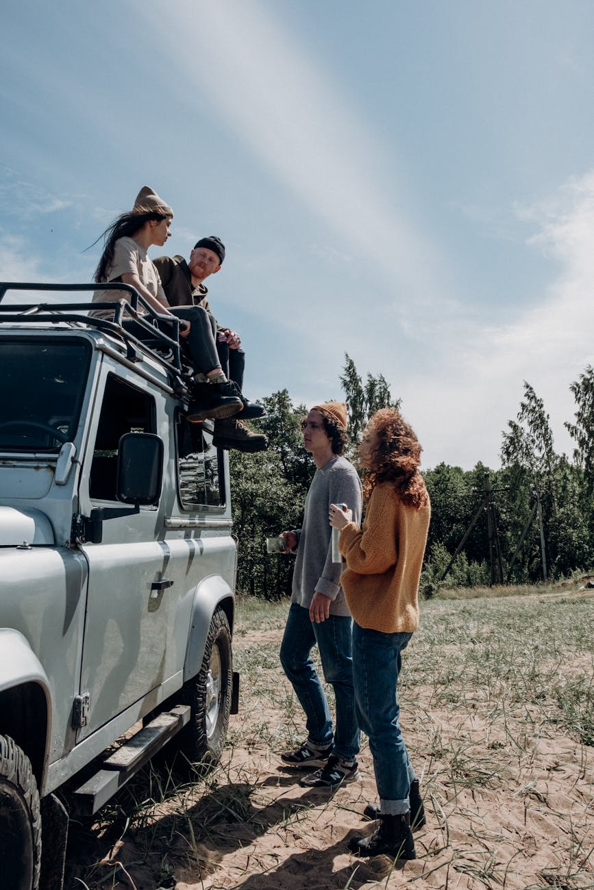 man and a woman sitting above a land rover defender