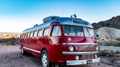 red and silver bus parked on the ground