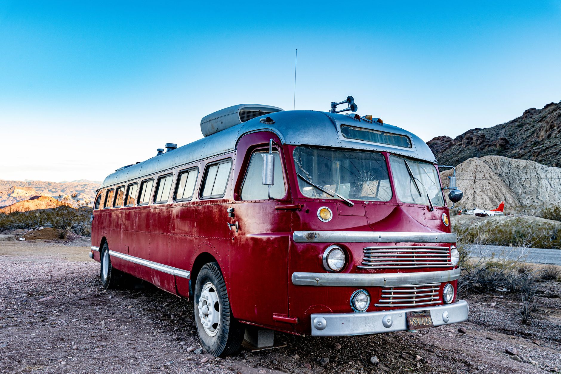 red and silver bus parked on the ground