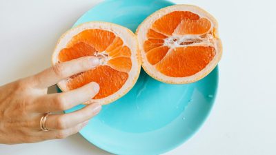 person touching sliced orange fruit
