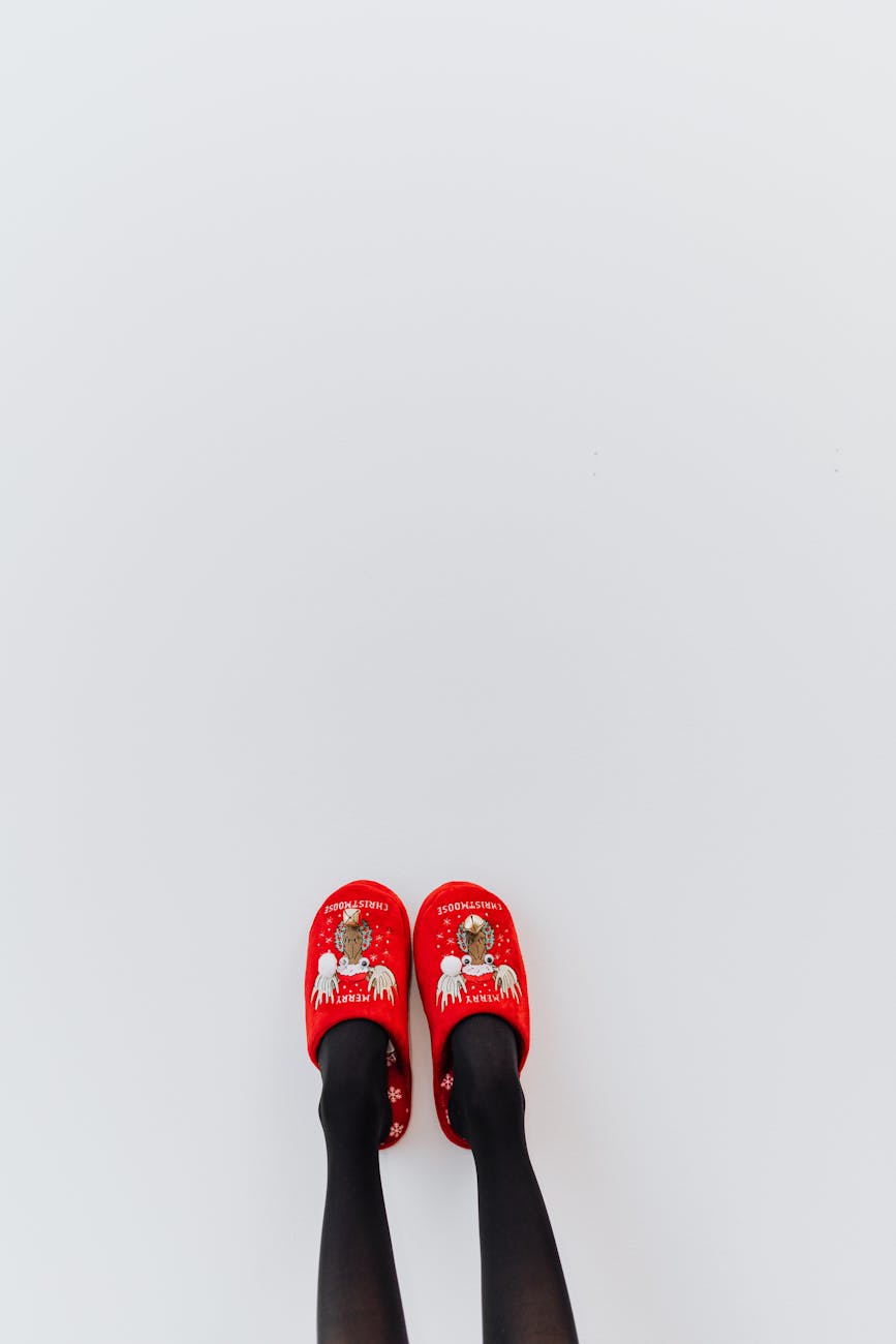 a person wearing christmas slippers on a white background