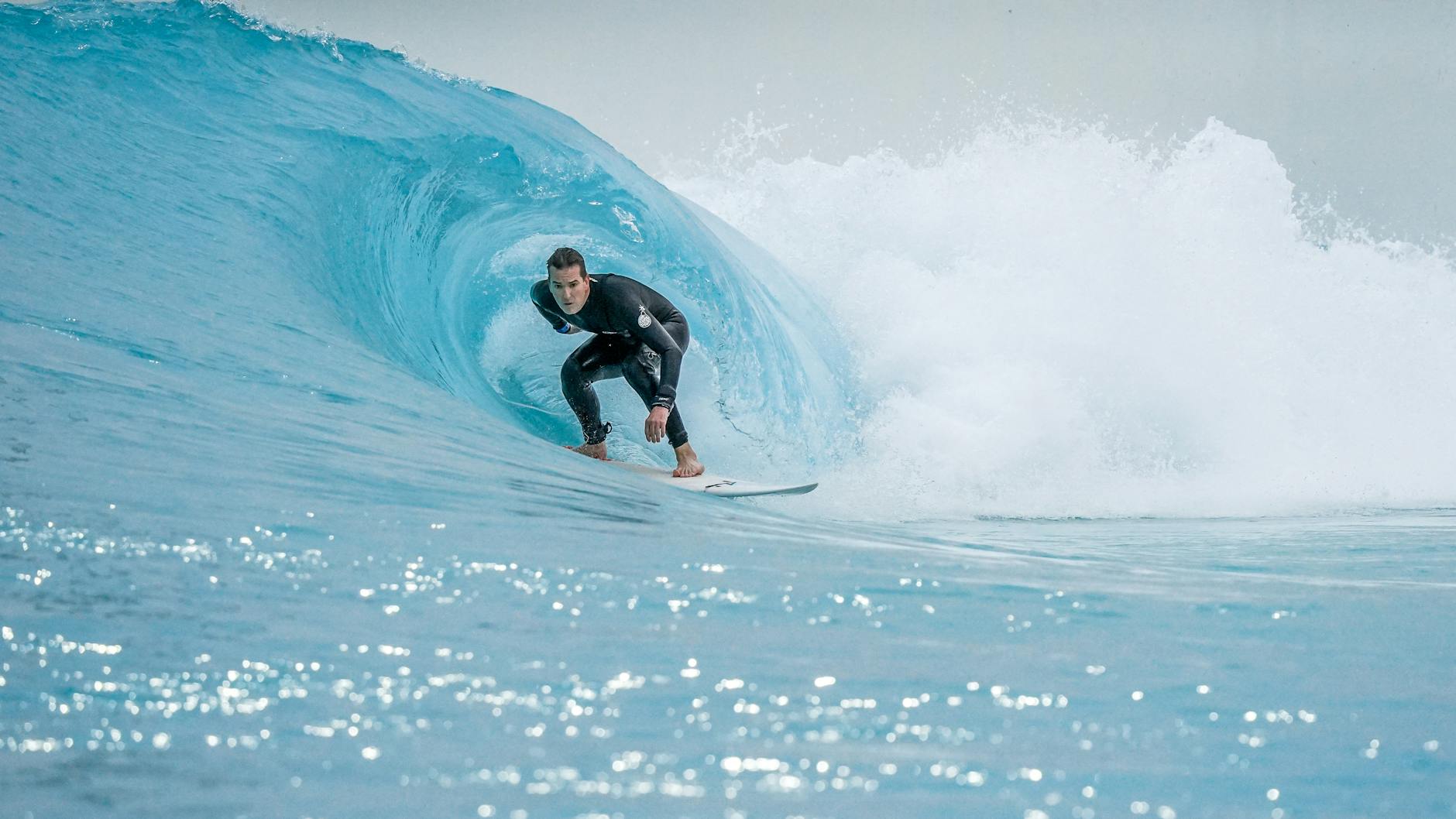 a man in a wetsuit surfing a wave