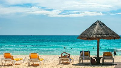 white and yellow lounge chairs on beach under blue sky