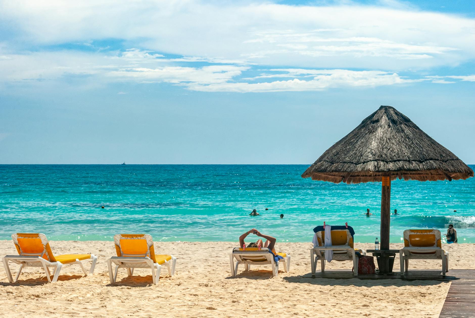 white and yellow lounge chairs on beach under blue sky