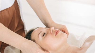 a person massaging woman s face