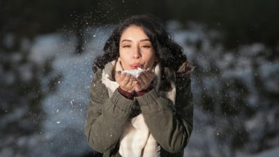 woman blowing snow outdoors