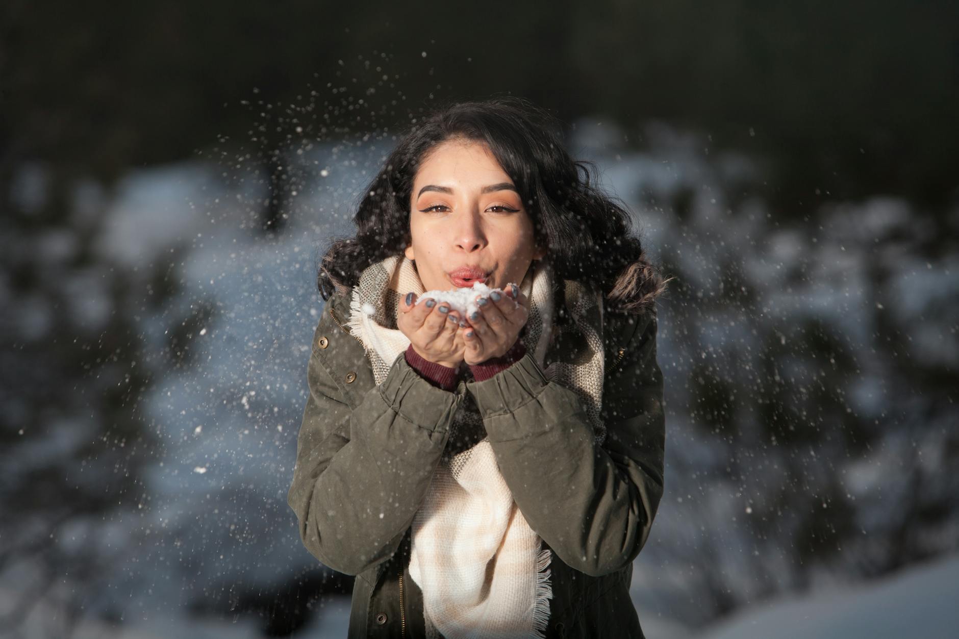 woman blowing snow outdoors