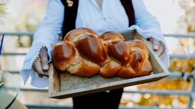 close up photo of person holding a tray of freshly baked bread