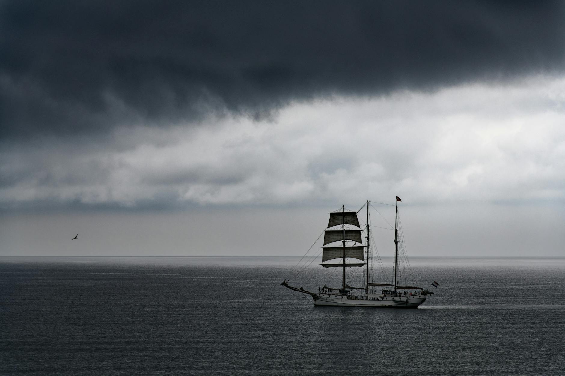 boat sailing on sea under cloudy sky