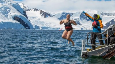 woman in black swimsuit jumping on water