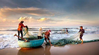 fishermen fixing nets on the seashore