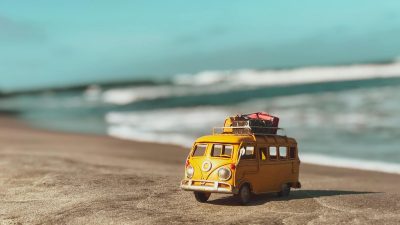 a yellow toy van on the beach