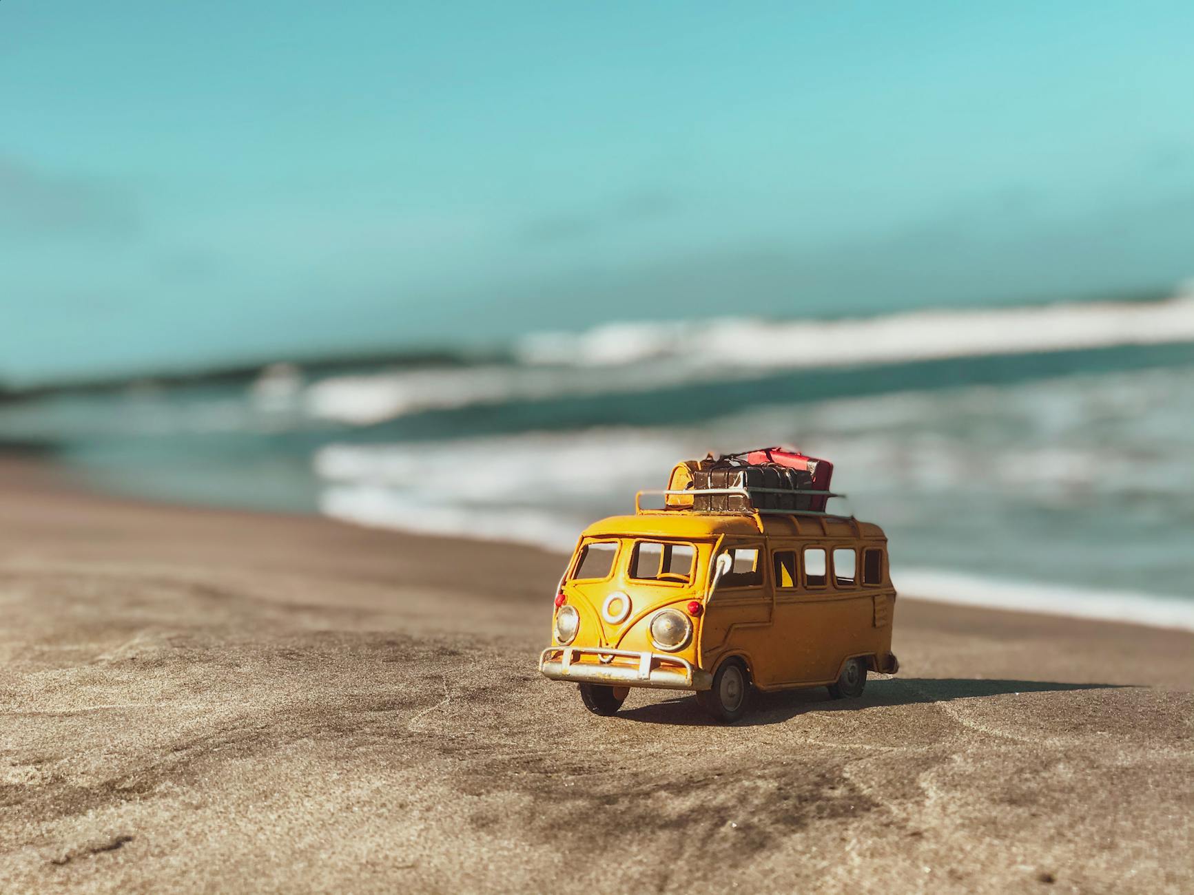 a yellow toy van on the beach
