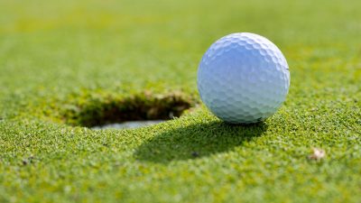 close up photo of golf ball near a hole