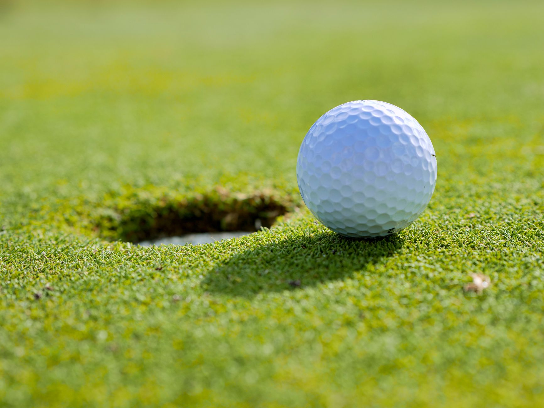 close up photo of golf ball near a hole