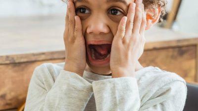 frustrated boy with his hands on his face