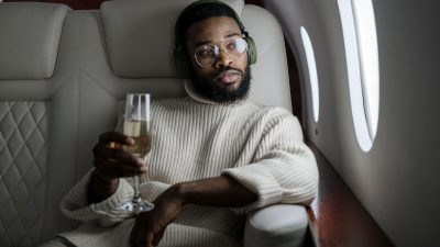 man inside an airplane holding a champagne glass