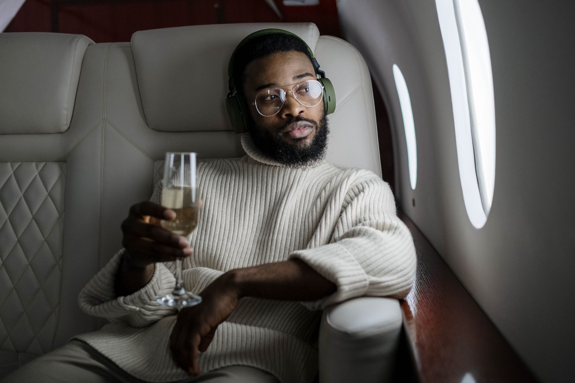 man inside an airplane holding a champagne glass