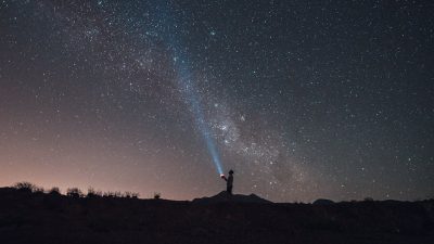 figure of hiker with upward ray in dark