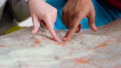 people pointing finger on map