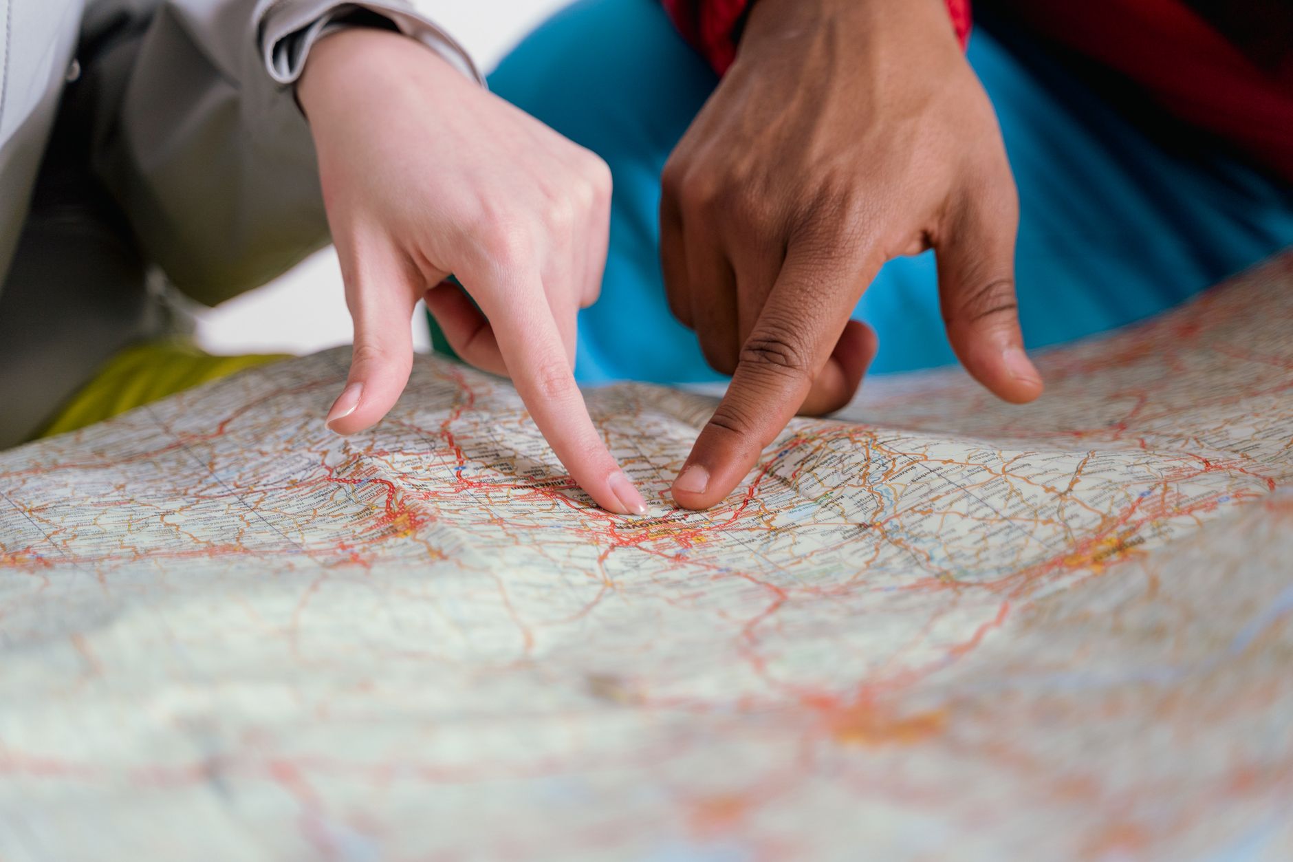 people pointing finger on map