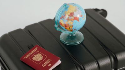 globe and passport on black luggage