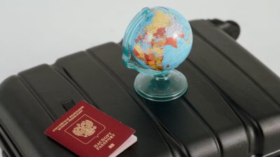 globe and passport on black luggage