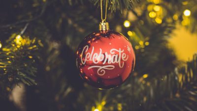 red celebrate print baubles hang on green christmas tree