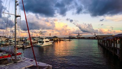 a harbour with ships boats and yachts moored at sunset