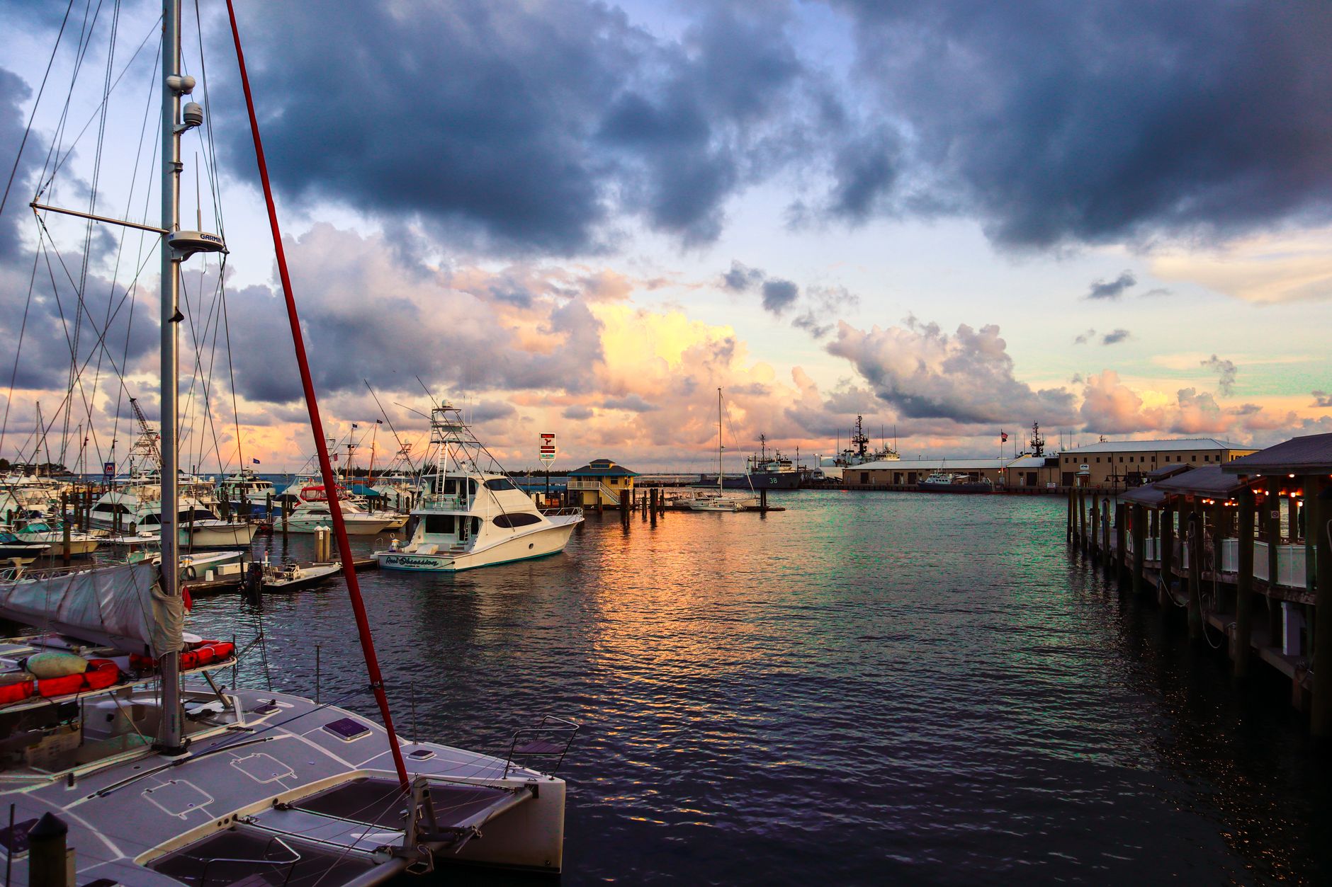 a harbour with ships boats and yachts moored at sunset