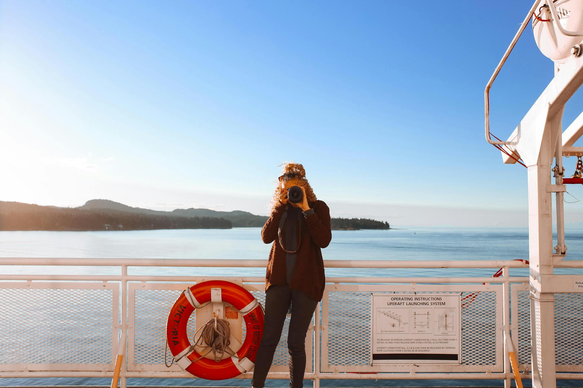 a person taking a photo while standing near metal railing