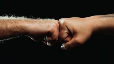 close up of two people fist bumping each other