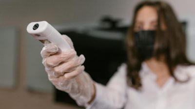 a woman holding an infrared thermometer