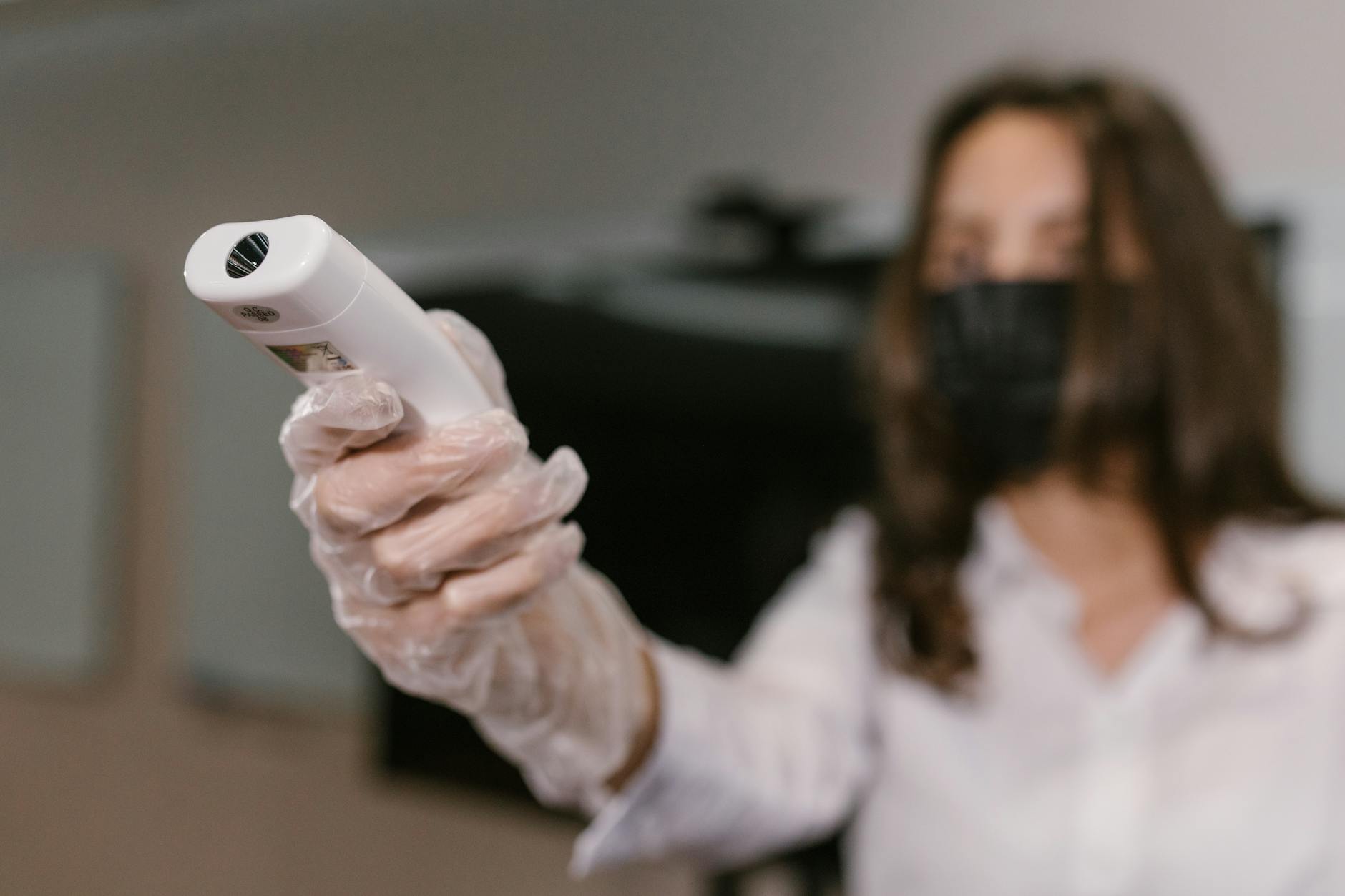 a woman holding an infrared thermometer
