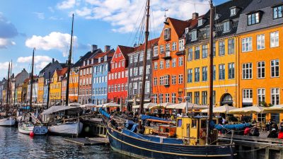 boats with masts moored by colorful tenements in nyhavn in copenhagen