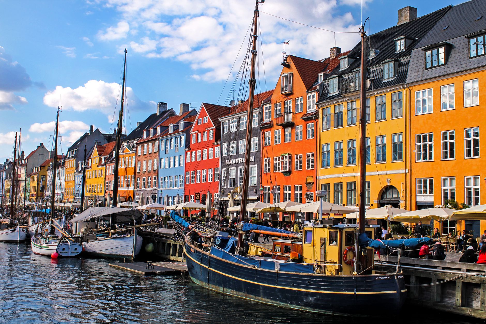 boats with masts moored by colorful tenements in nyhavn in copenhagen