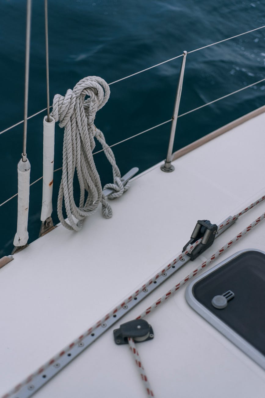 a white rope tied on metal railing of a boat