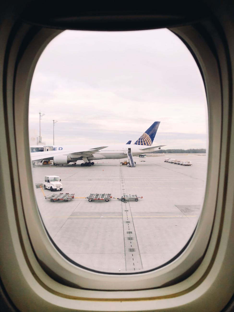 view of airplanes at the airport seen from an airplane window