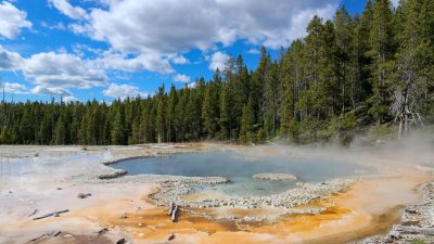 the yellowstone national park under blue sky with white clouds
