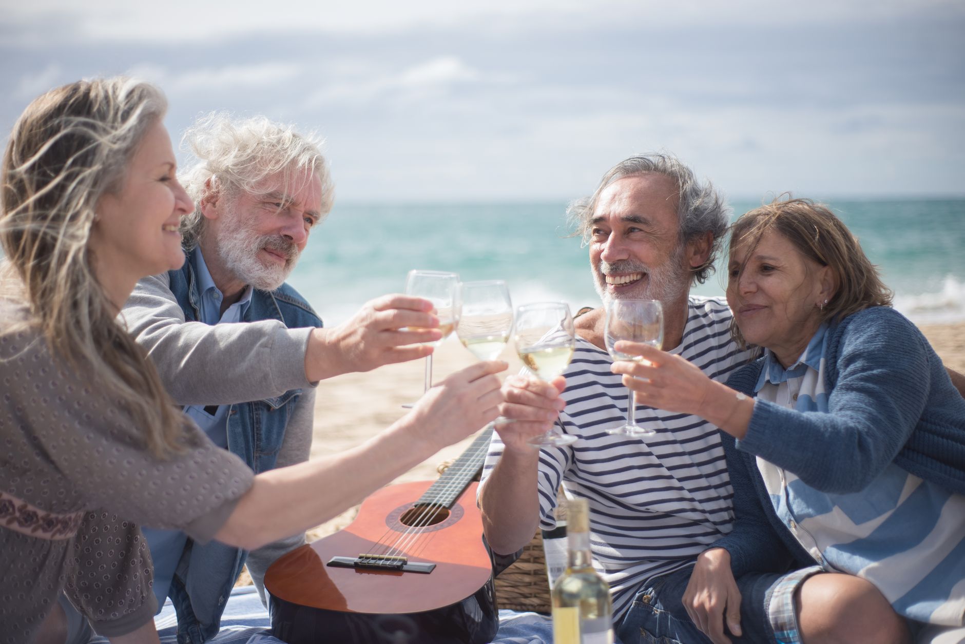 gray haired people toasting wine glasses