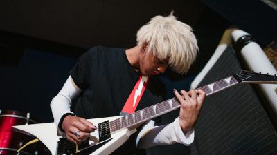 low angle shot of a blond haired man playing electric guitar