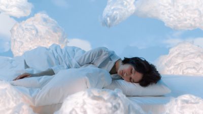 photo of a woman sleeping near fluffy clouds