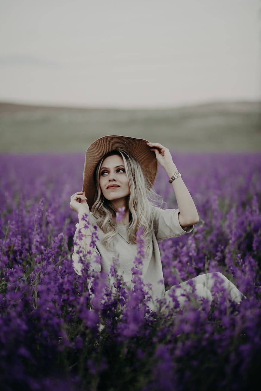 woman sitting in field of violet flowers