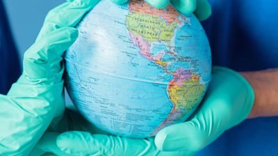 people wearing latex gloves holding a globe