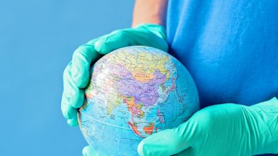 a person wearing gloves holding globe
