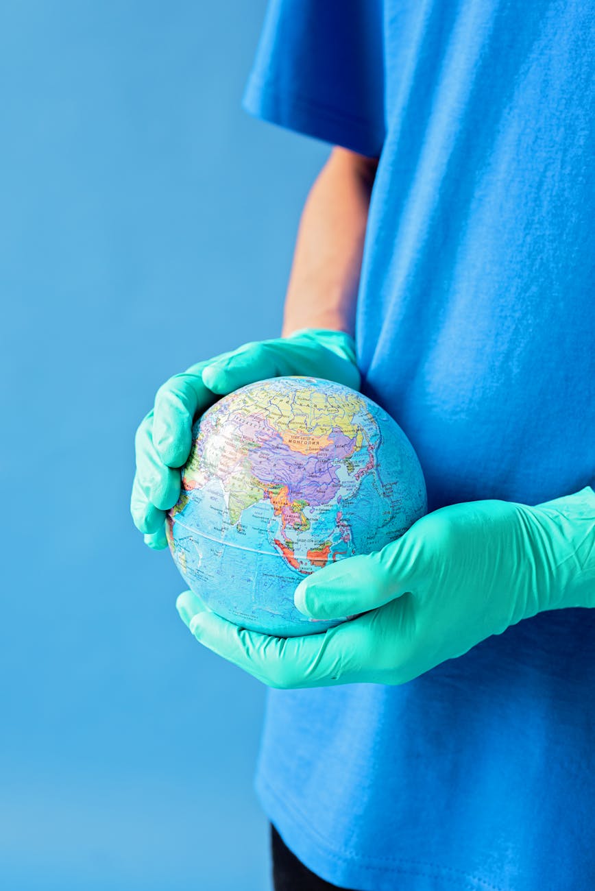 a person wearing gloves holding globe