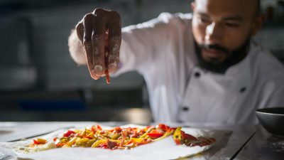 a chef putting ingredients on top of the dough