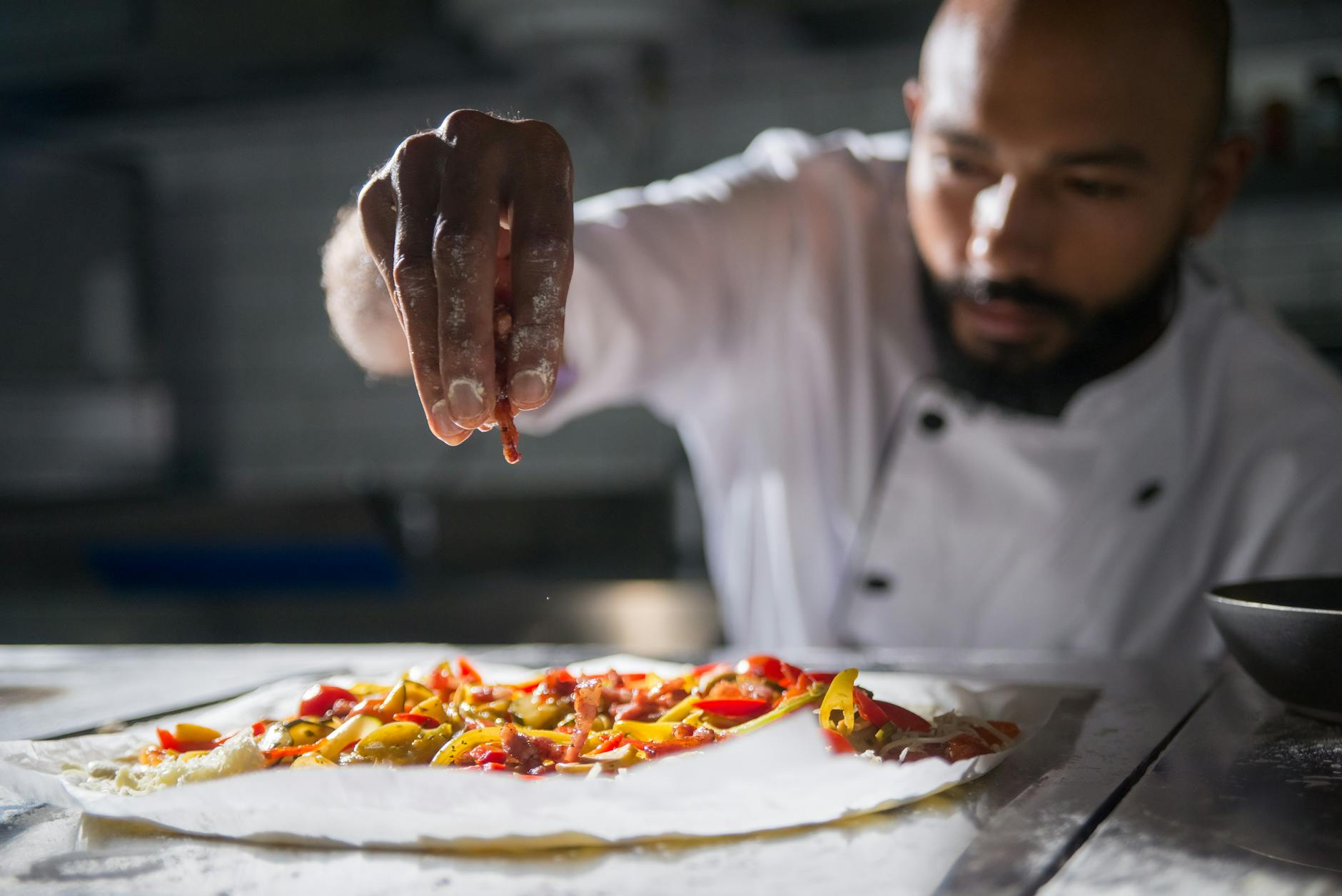 a chef putting ingredients on top of the dough