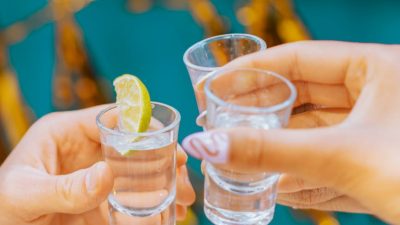 holding shot glasses with vodka